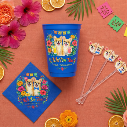 Colorful party set with a blue cup, napkin, and straws featuring corgi design on an orange background with flowers and leaves.
