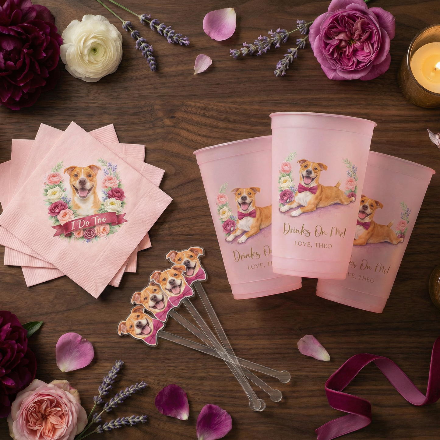 Pink party supplies with dog illustrations on a wooden table with flowers and candles.